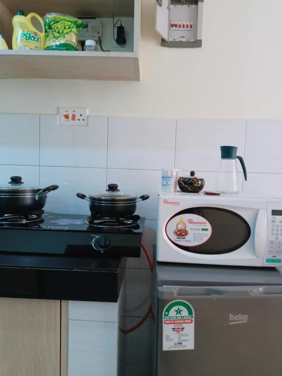 a kitchen with a stove with pots and pans on it at Syokimau Airport Haven in Syokimau
