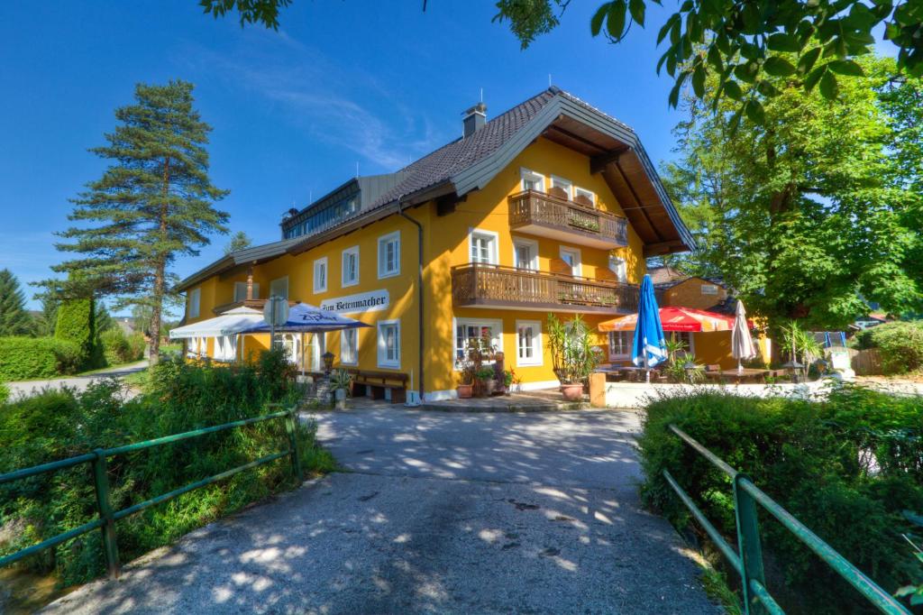 uma grande casa amarela com uma varanda em Landgasthof zum Betenmacher em Thalgau