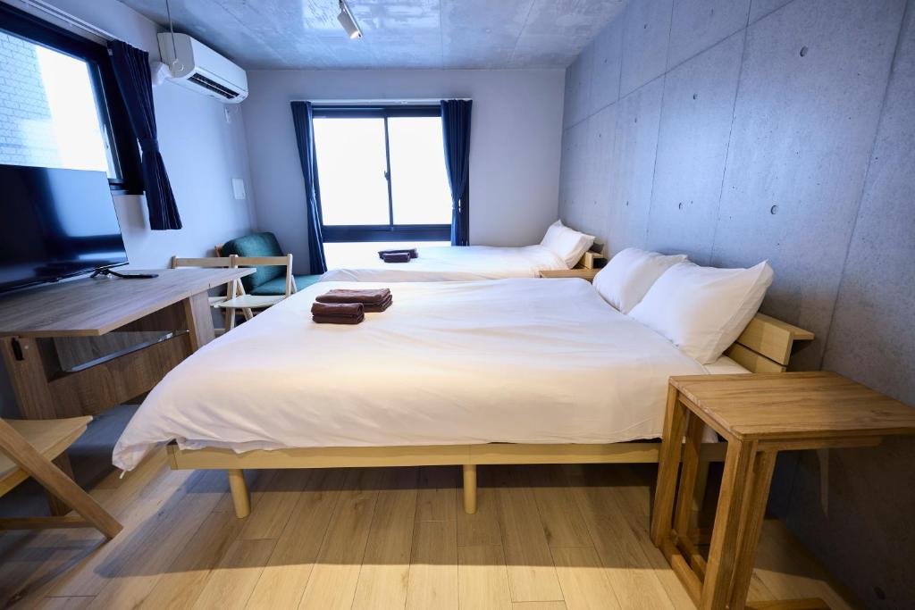a bedroom with a large white bed and a window at OPUS Haneda in Tokyo