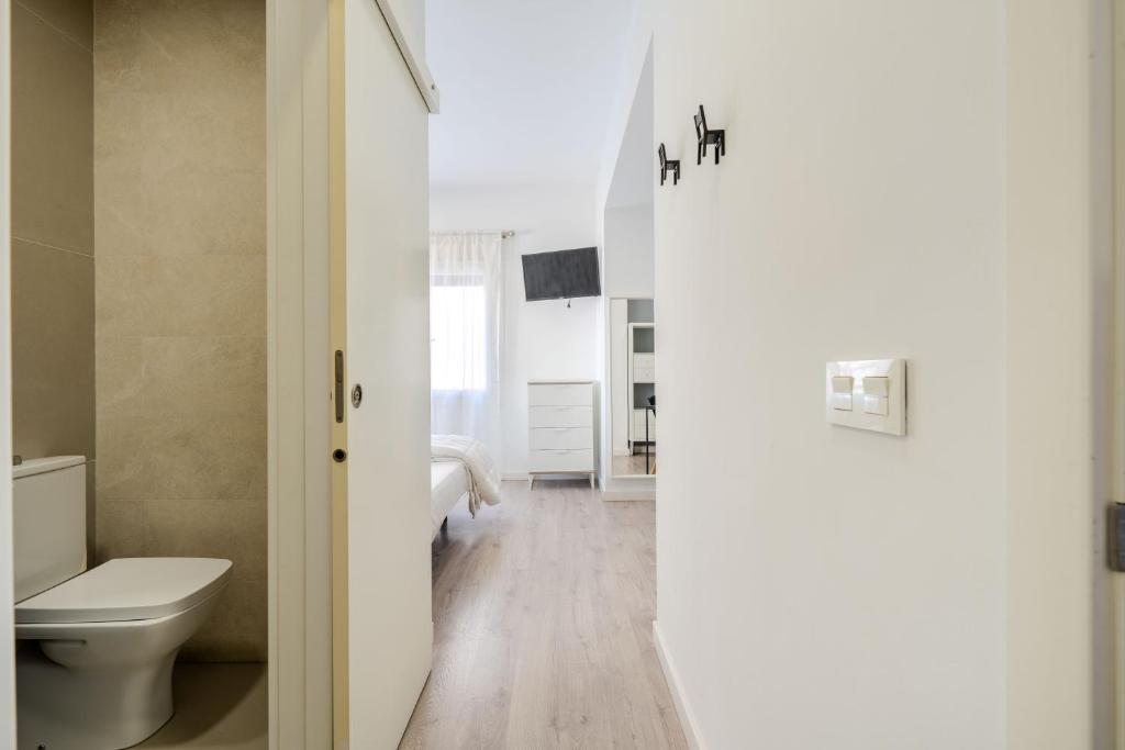 biała łazienka z toaletą i umywalką w obiekcie BF Rooms Almeria Centro w mieście Almería