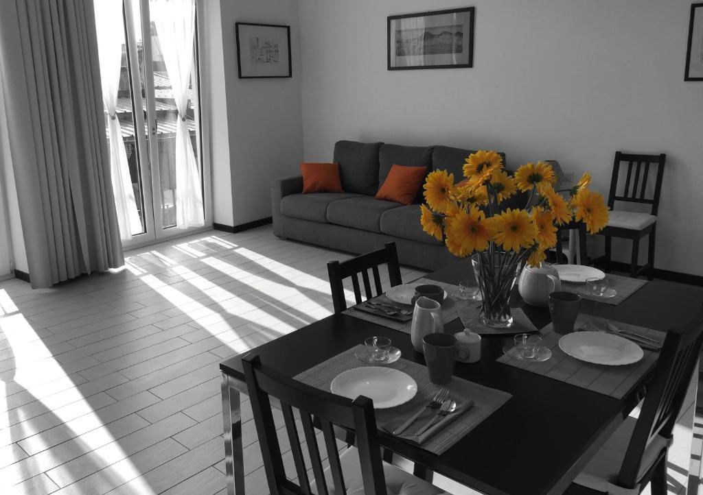sala de estar con mesa con flores y sofá en SweetHomeToledo, en Nápoles