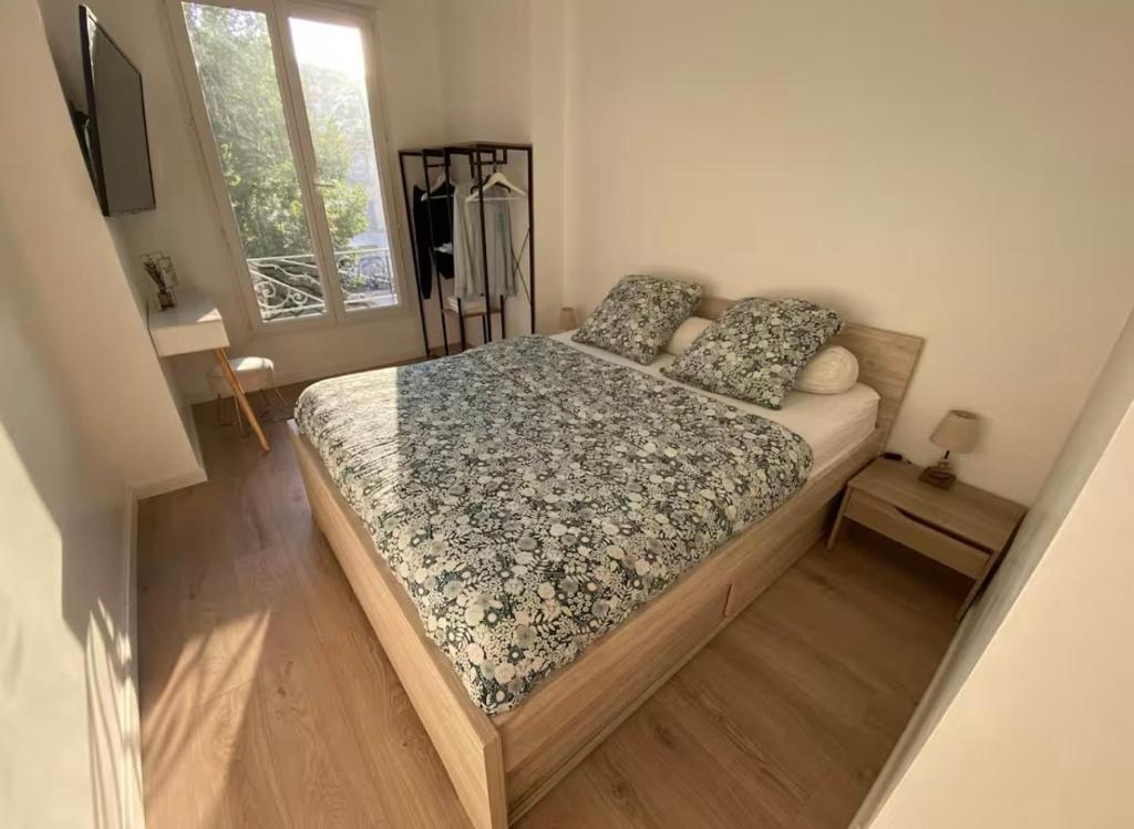 une chambre avec un lit avec un couvre-lit fleuri dans l'établissement Appartement Nice 2 chambre 2 lits 1 salle de bain, à Nice