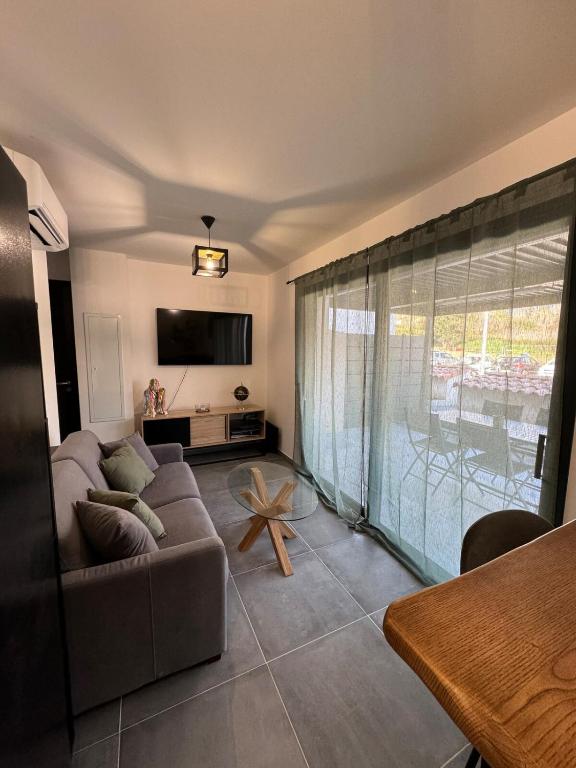 un salon avec un canapé et une table dans l'établissement T2 duplex en RDC, à Bastelicaccia