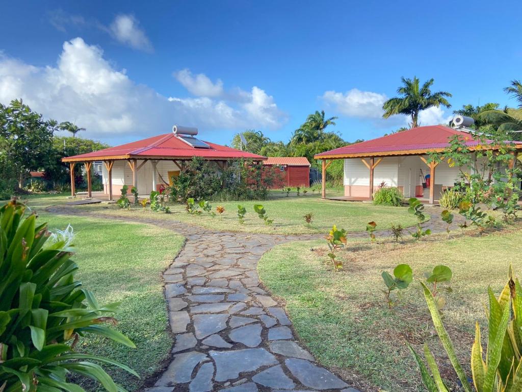 a walkway in front of two houses and a yard at Le Royal Horizon in Deshaies