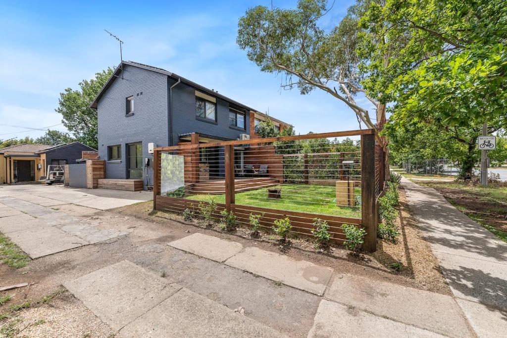 a house with a fence in front of a yard at 3 Bed Fully Renovated with Outdoor Fun in Watson