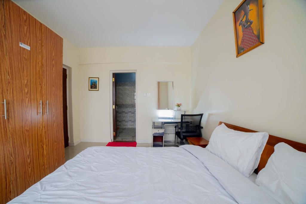 una camera con letto e scrivania con computer di Airport Vista Getaway-4km from jomo Kenyatta International Airport a Nairobi