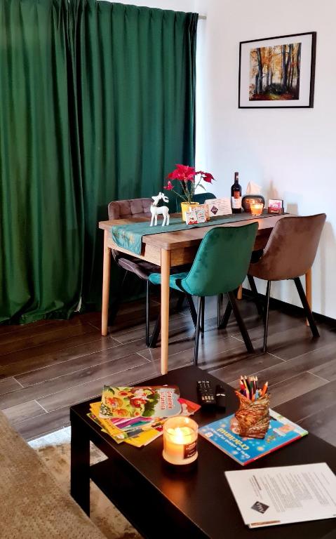 a living room with a table and a green curtain at Casa Ama in Buşteni