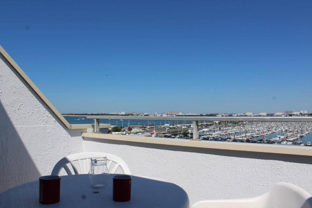une table et des chaises sur un balcon avec vue sur la plage dans l'établissement Appartement 2 pièces - LA ROCHELLE - LR240-602, à La Rochelle