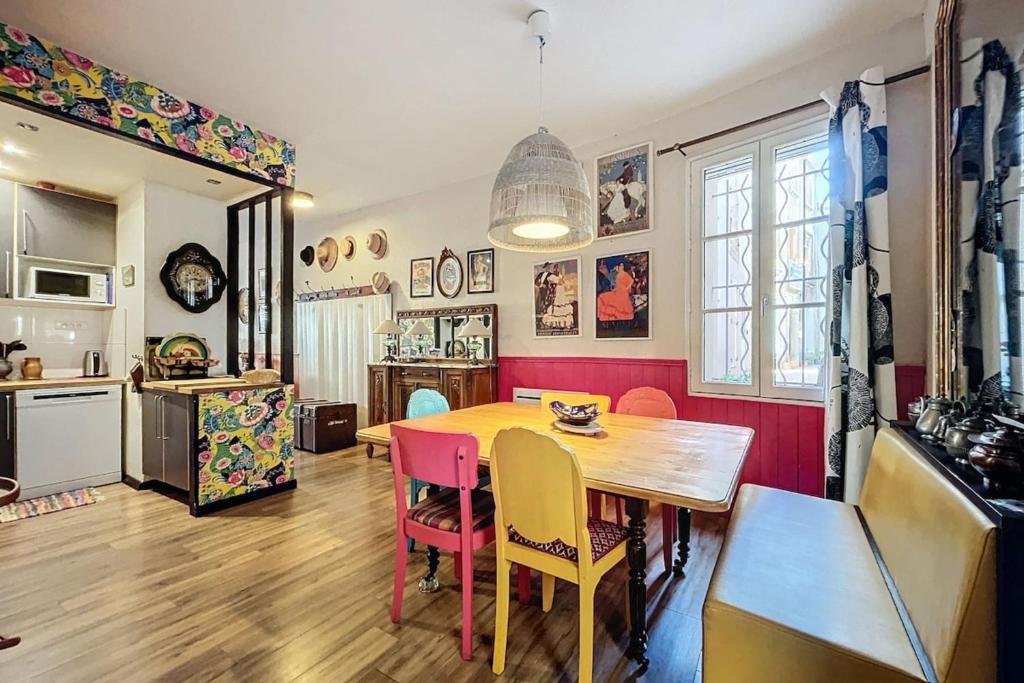 a kitchen and dining room with a table and chairs at La Bade - Maison d'artiste proche des pontons in Peyriac-de-Mer