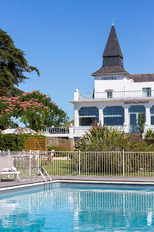 une maison avec piscine devant un immeuble dans l'établissement Hotel Restaurant Spa du Tumulus Carnac, à Carnac