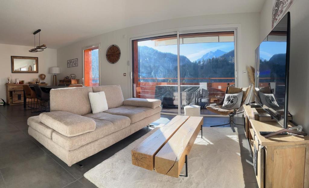 un salon avec un canapé et une table dans l'établissement Grand Duplex Lumineux - 3 chambres, à Saint-Jean-de-Sixt