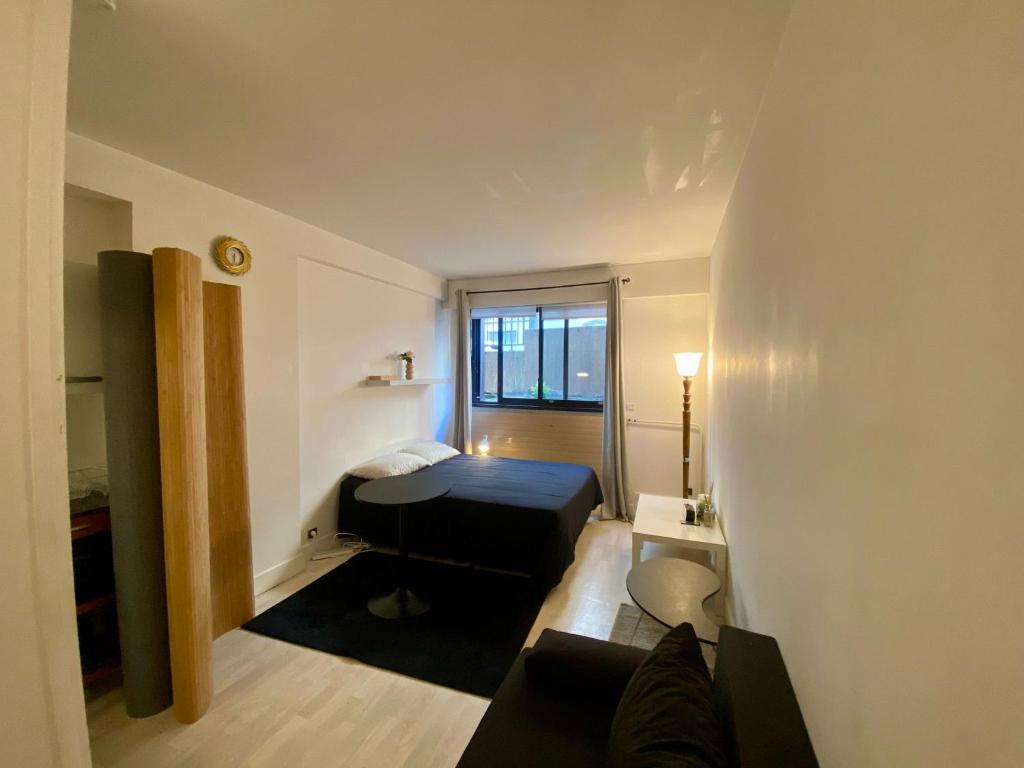 une petite pièce avec un lit et une fenêtre dans l'établissement Studio Kennedy Passy Tour Eiffel, à Paris