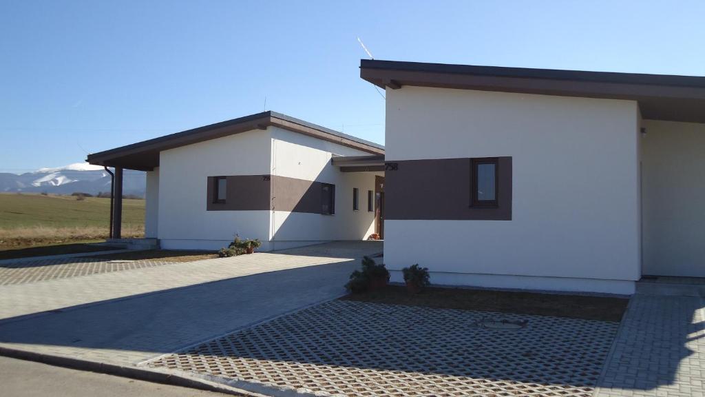 uma casa branca com um telhado preto em Apartments Valentka em Bešeňová