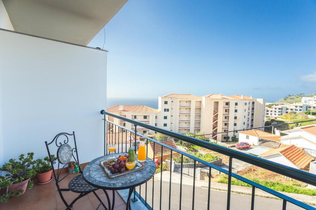 a balcony with a table with fruit on it at Charming Garajau by AH in Caniço