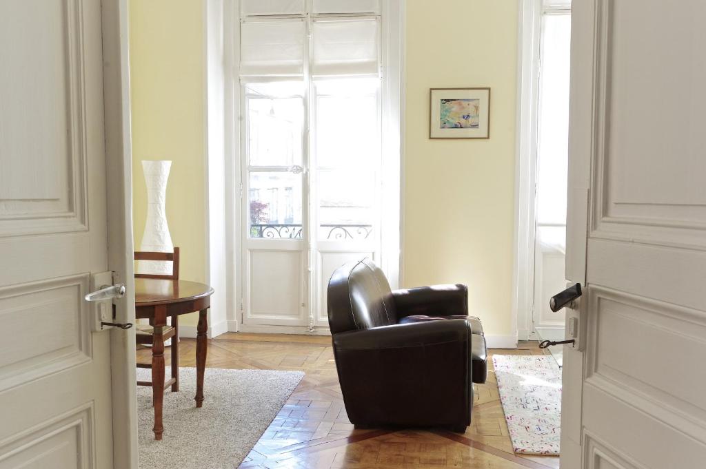 - un salon avec une chaise noire et une table dans l'établissement Louis Combes - Localisation exceptionnelle 1 chambre parking, à Bordeaux