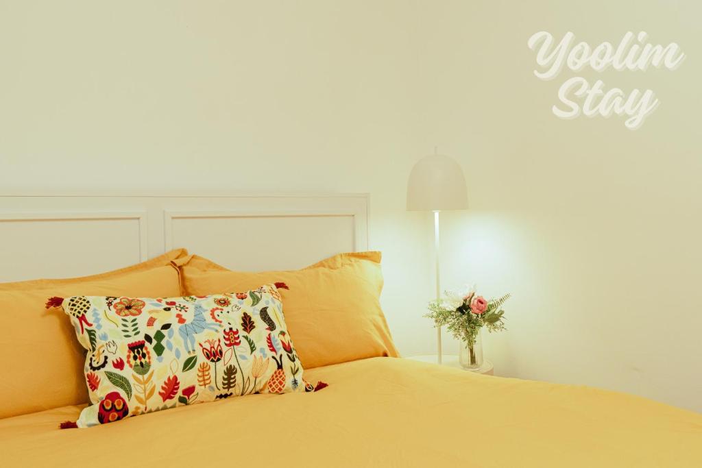 a bedroom with a yellow bed with a pillow and a lamp at Yoolim stay # 건대입구# 성수# 잠실롯데타워 in Seoul