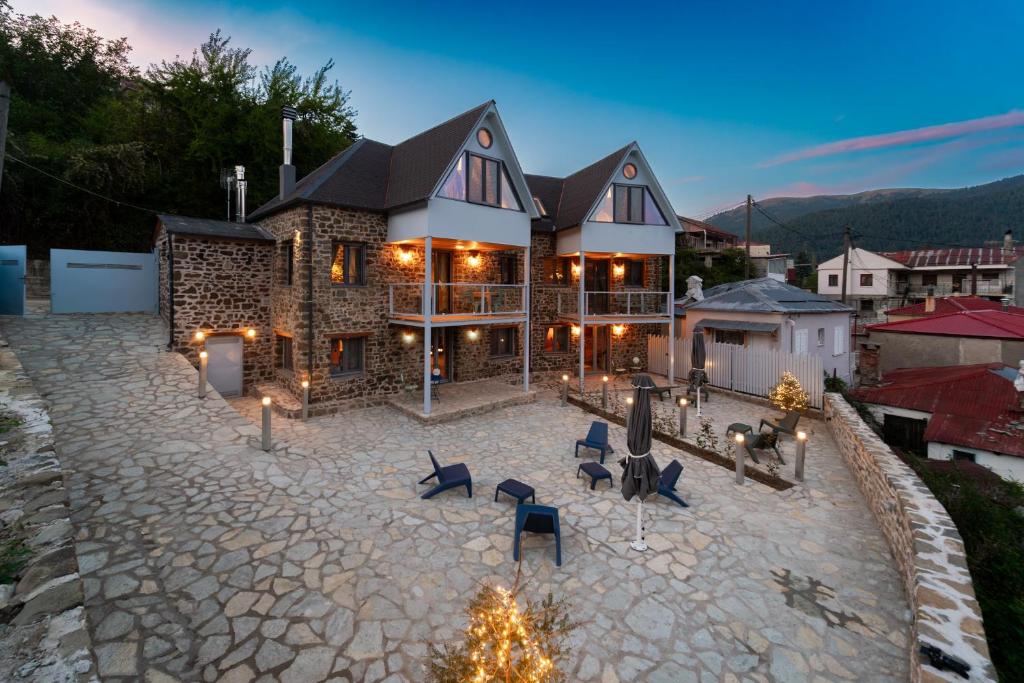 een groot huis met een stenen oprit ervoor bij Dandy Villas Karpenisi Complex - Lux Chalets - Inflatable Pool-Hot Tub in Áyios Nikólaos