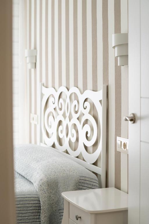 a bedroom with a bed with a white headboard at APARTAMENTO SAN MIGUEL N.2 in Jarandilla de la Vera