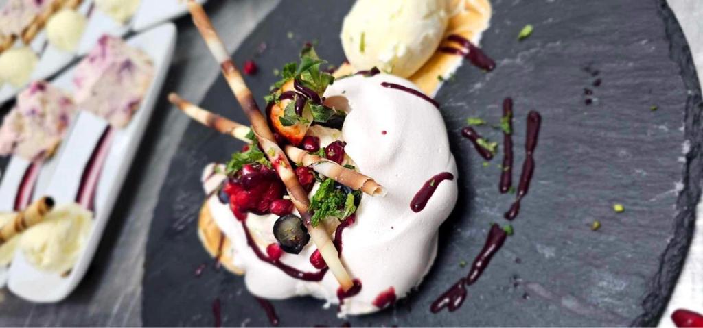 a dessert on a gray plate with whipped cream at Bowood Park Hotel in Camelford
