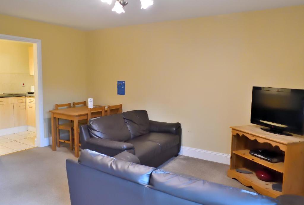 a living room with a couch and a flat screen tv at Bowood Park Hotel in Camelford