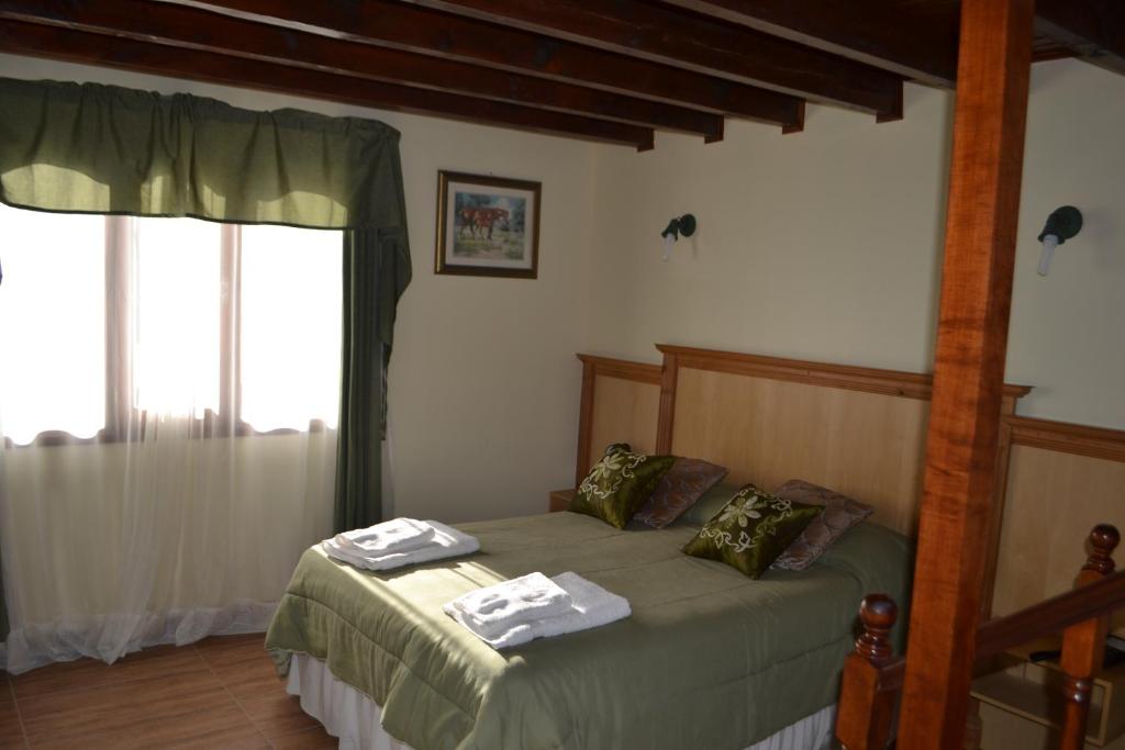 um quarto com uma cama com toalhas em Valle Frío Ushuaia em Ushuaia