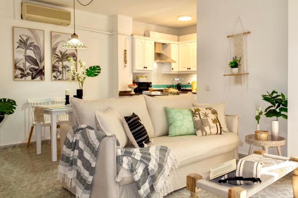 a living room with a white couch and a kitchen at Esmeralda HOME JÁVEA in Jávea