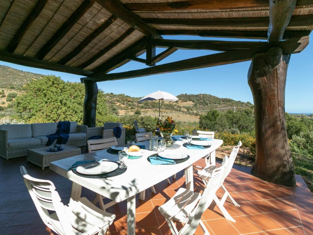 a table and chairs on a patio with a view at Villa Clara in Tertenìa