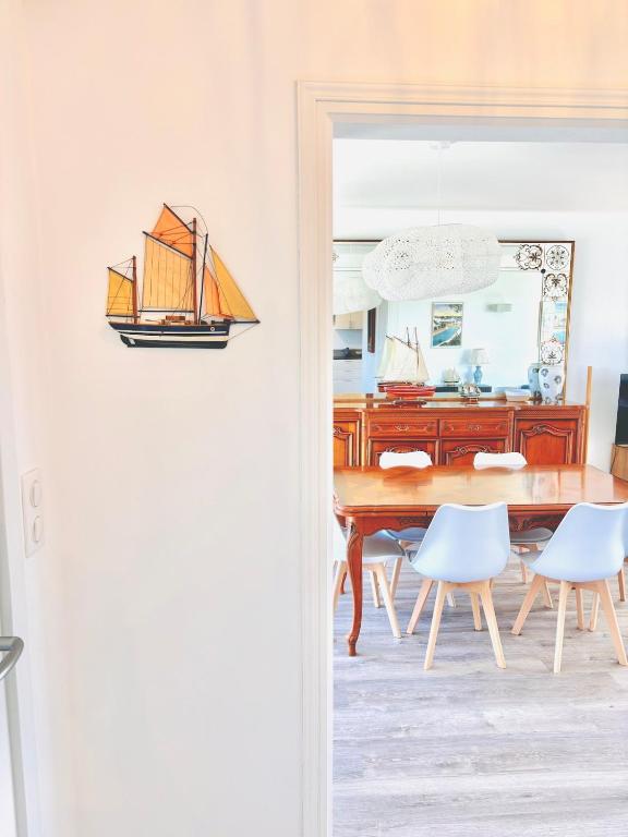 une salle à manger avec une table et des chaises en bois dans l'établissement NOUVEAU! - maison a 500m de la plage, à Névez