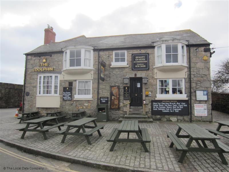 um grupo de mesas de piquenique em frente a um edifício em The Dolphin Tavern em Penzance