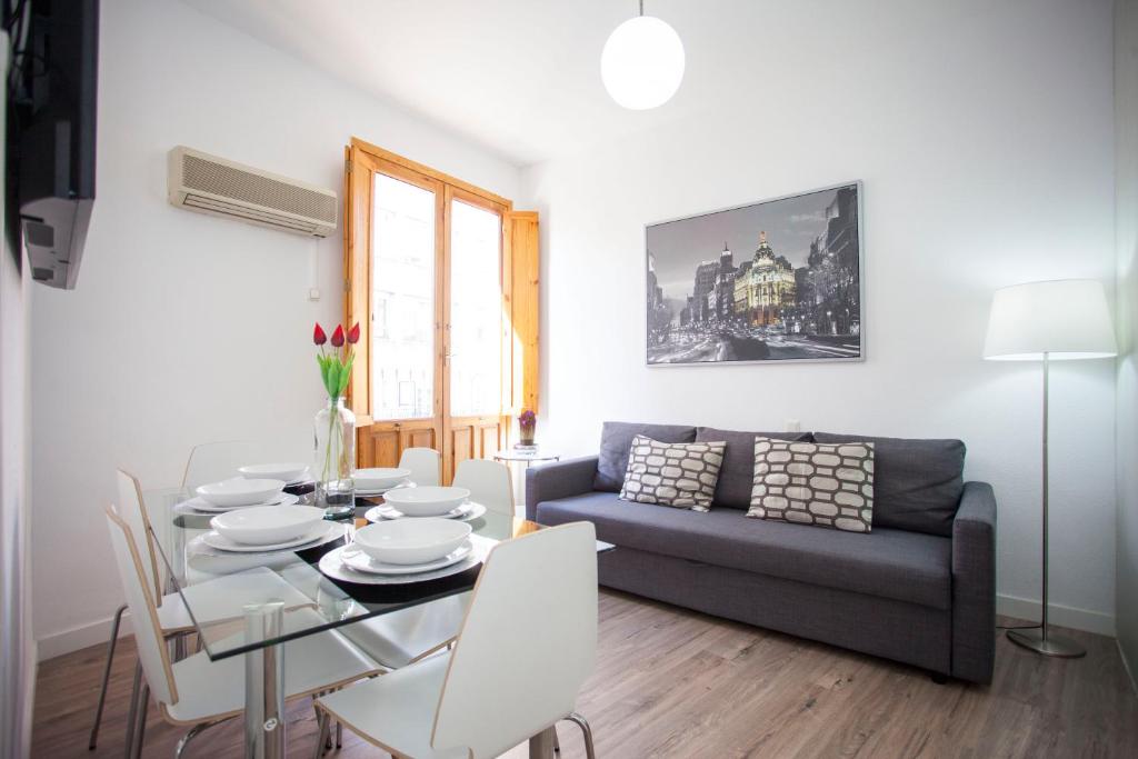 - un salon avec une table et un canapé dans l'établissement Fuencarral Apartments, à Madrid