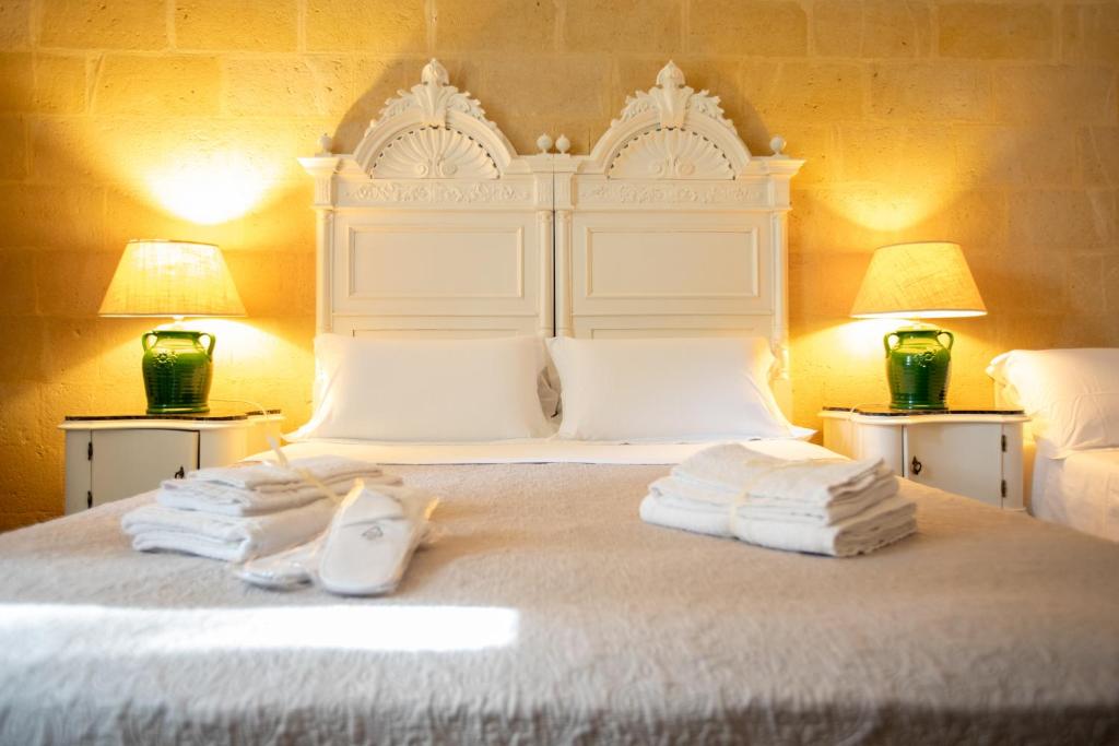 a bedroom with a bed with towels on it at VILLA LA TONNARA in Punta Prosciutto