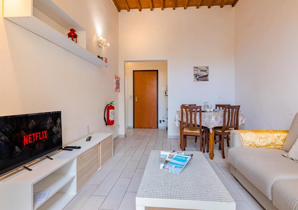 a living room with a couch and a tv and a table at Casa Mya-Relax al Porto, WiFi Veloce e Clima in Livorno