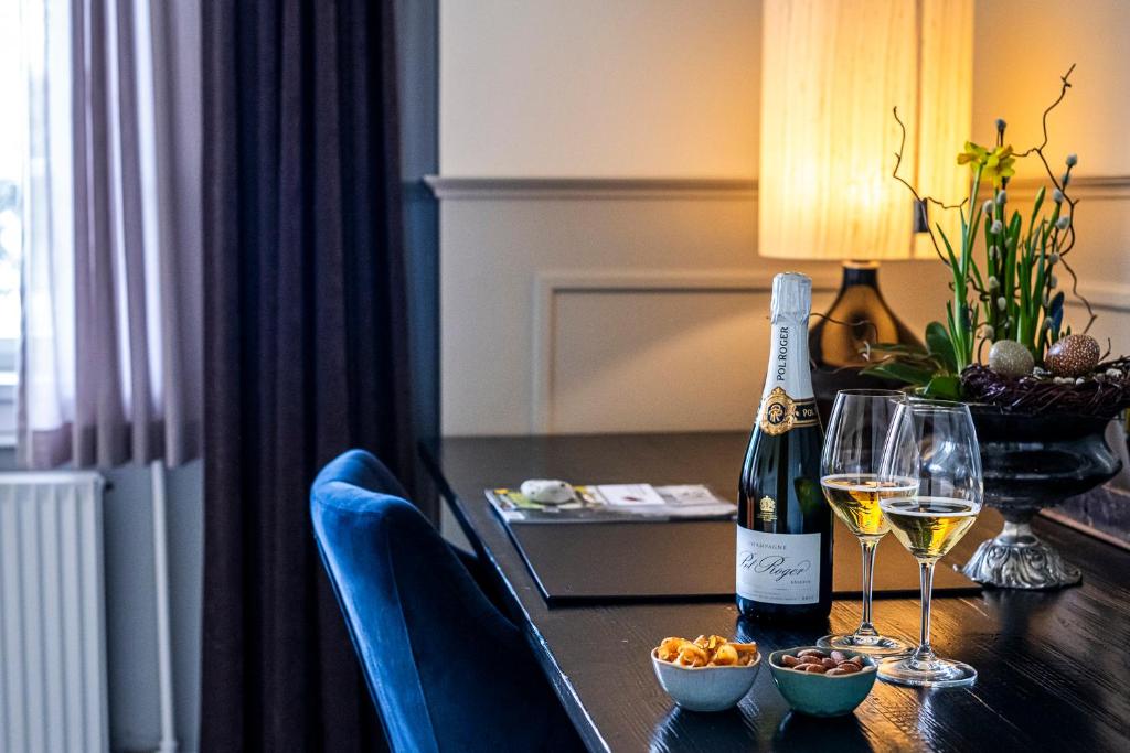 a table with a bottle of wine and two glasses at Gl. Avernæs Sinatur Hotel & Konference in Ebberup