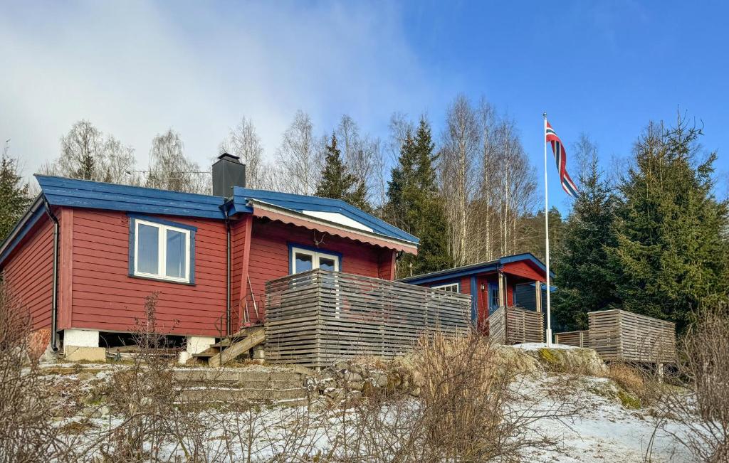a red house with a flag in front of it at 2 Bedroom Lovely Home In Enebakk in Sand