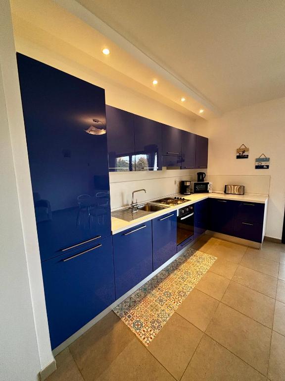 une cuisine avec des armoires bleues et un évier dans l'établissement Appartement DU MAS, à Saint-Florent