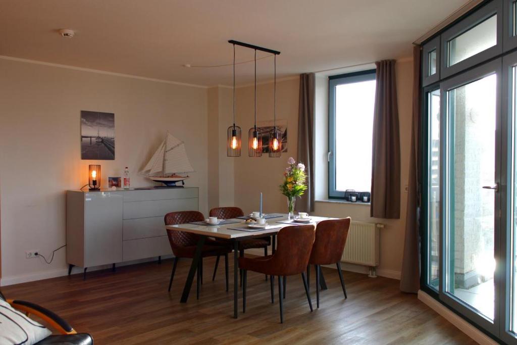 a kitchen and dining room with a table and chairs at Inselblume 55 - Ferienwohnung in der Strandburg mit Hund in Burgtiefe auf Fehmarn 