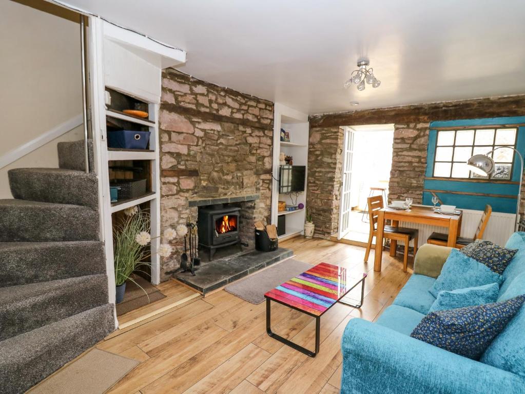 a living room with a blue couch and a fireplace at Rhif Deg in Brecon