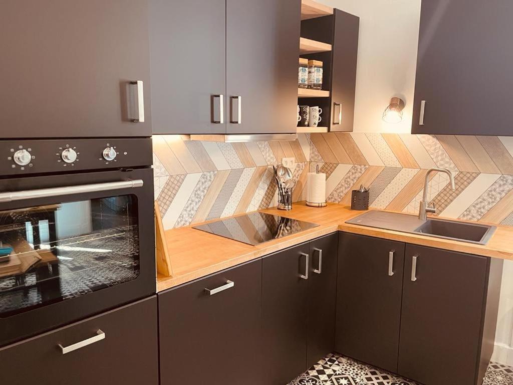une cuisine avec un évier et une cuisinière dans l'établissement Appartement Brulart, à Reims