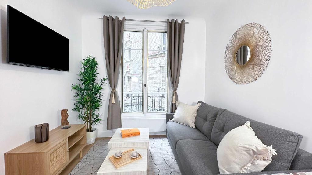 - un salon avec un canapé gris et une fenêtre dans l'établissement Brand new flat near Eiffel Tower, à Paris
