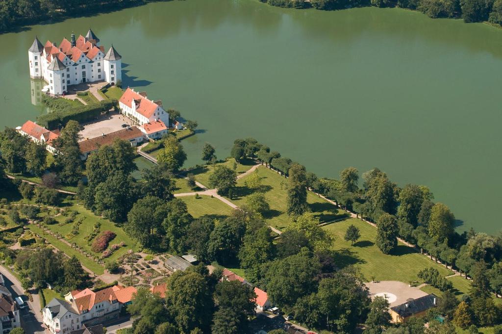 una vista aérea de un castillo en una colina junto a un lago en Schloss Glücksburg, en Glücksburg