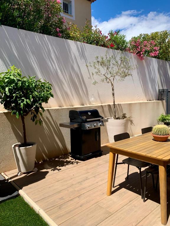 d'une terrasse avec une table en bois et un grill. dans l'établissement Villa Évasion Saint-Cyrienne, à Saint-Cyr-sur-Mer