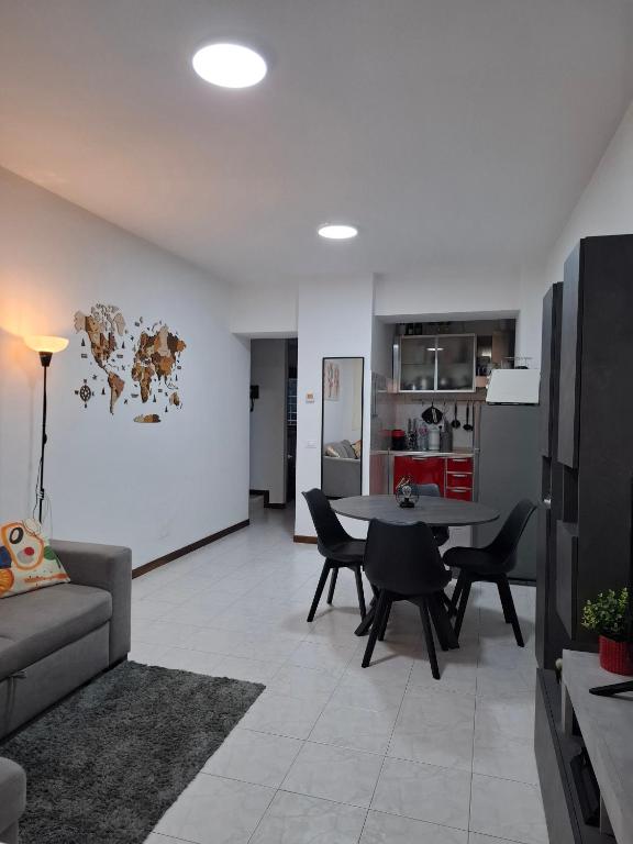 a living room with a table and chairs and a kitchen at Valle Cinque in Fano