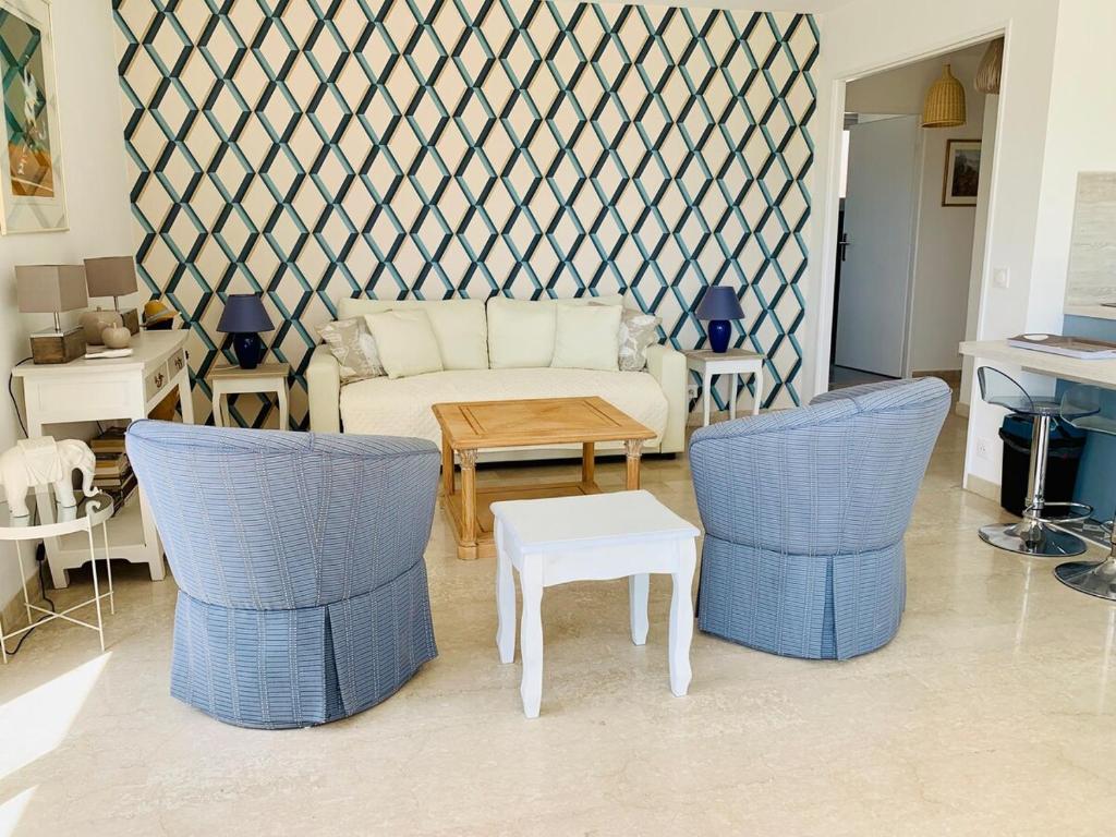 un salon avec un canapé, des chaises et une table dans l'établissement charmant appartement vue mer proche palais, à Cannes
