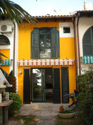 a yellow and white building with green shutters at Casa 812 in Caleri