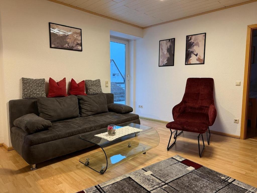 a living room with a couch and a chair at Ferienwohnung mit Terrasse in Insheim