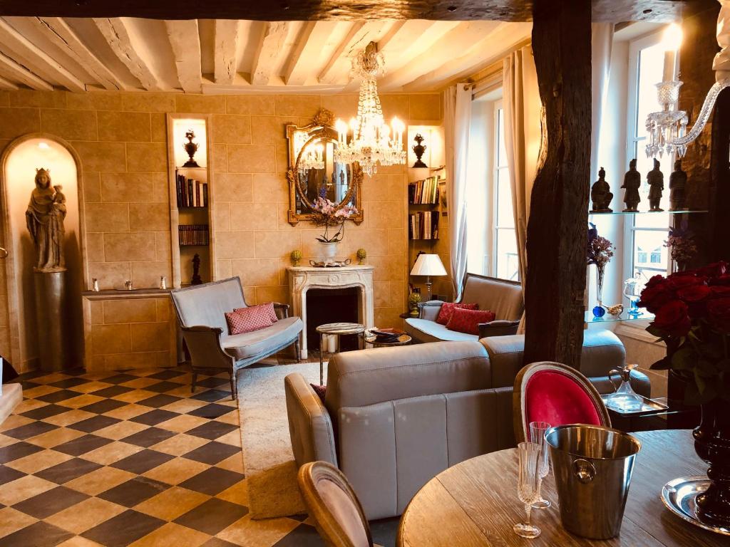 un salon rempli de meubles et d'un lustre dans l'établissement Place Dauphine, à Paris