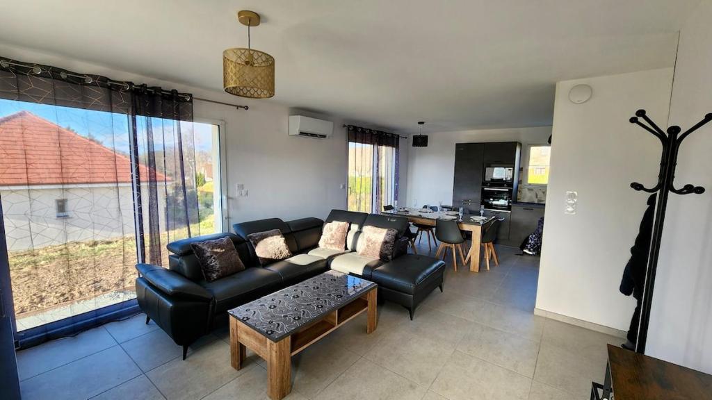 un soggiorno con un divano e un tavolo di Gîte cosy près de la mer - Maison familial tout équipé - Côte d'Albâtre a Cany-Barville