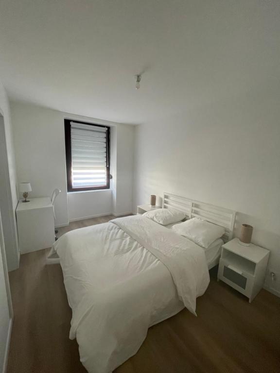 a white bedroom with a large bed and a window at Riedisheim Cozy in Riedisheim