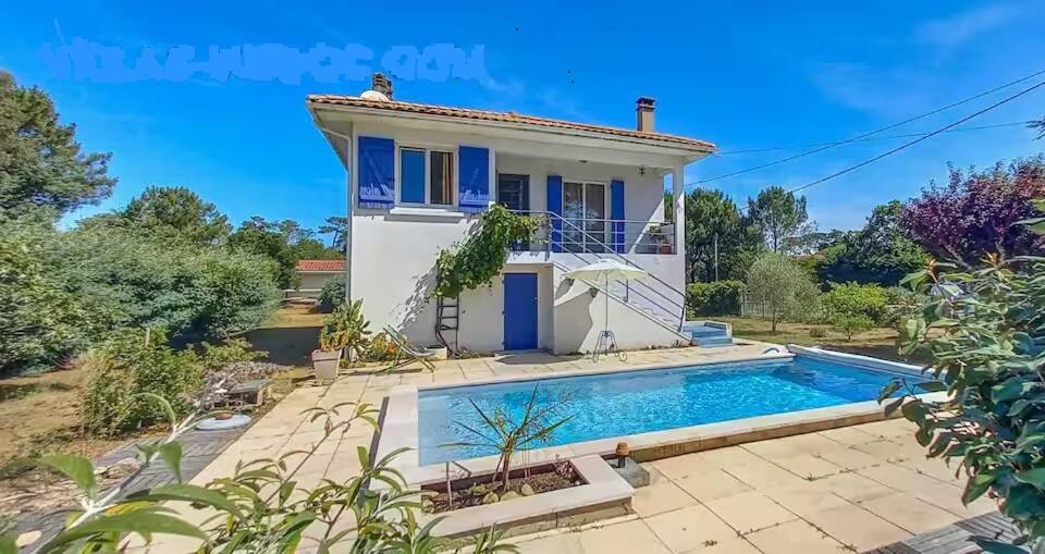 une maison avec une piscine devant dans l'établissement la maison bleu, à Montalivet-les-Bains