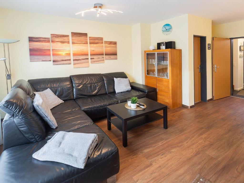 a living room with a leather couch and a coffee table at Ferienhaus Marisol, FeWo Vermittlung Nordsee in Dangast